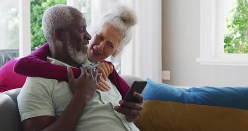 Senior Couple Embracing and Looking at Phone