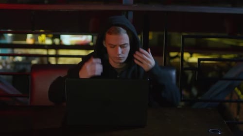 Hacker Developing Computer Code in Bar