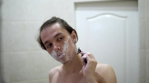 Cara raspando a sombra das cinco horas na frente do espelho