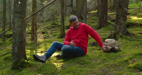 Tourist Guy Resting on Moss in a Beautiful Forest