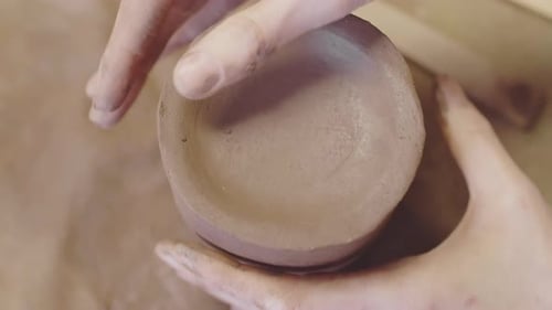Hands Shaping Clay into a Bowl