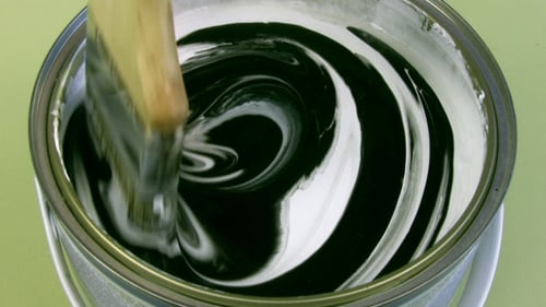 Black Paint Stirred Into White Paint Inside Can