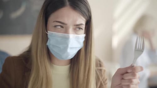 Woman Wearing Mask Cleaning Fork at Work