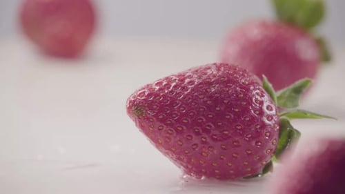 Strawberry Falls Down on Heap of Fresh Berries with Water Drops Slow Motion