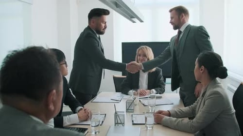 Businessmen Shaking Hands at a Conference Table