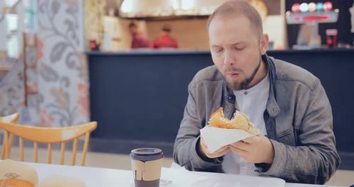 Man Eating a Burger in a Fast Food Cafe