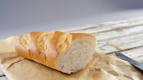 Sliced Crusty Bread on Paper with Knife