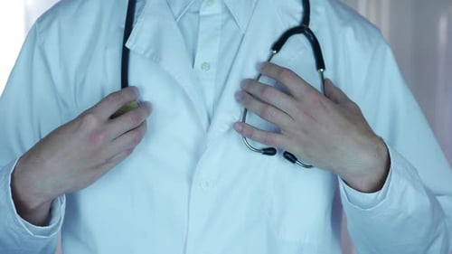 Doctor Adjusting Lab Coat with Stethoscope