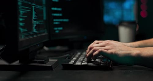Um programador de computador ou hacker imprime um código em um teclado de laptop para invadir