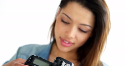 Woman Adjusting Camera in Bright Studio Setting