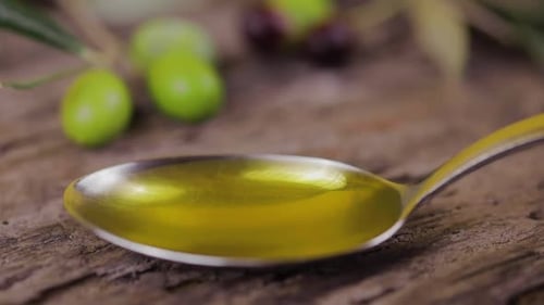 Olive Oil in Spoon with Olives and Leaves