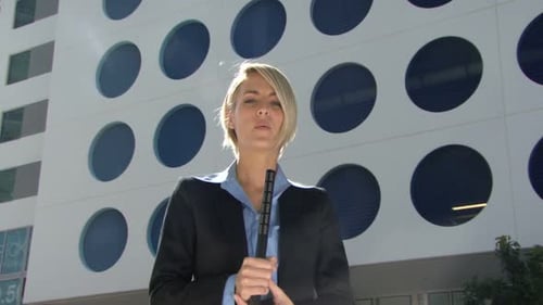 Woman Reporter Holding Microphone, Urban Setting