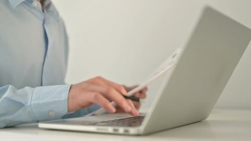 Hands Typing on Laptop and Taking Notes