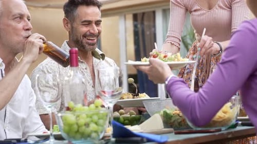 Friends Enjoying Meal Together Outdoors at Table