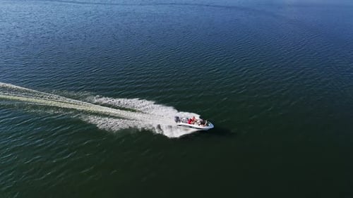Motorboat on blue water surface. Tourists travel in a high-speed boat in the sea.