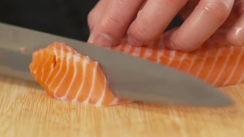 Sushi chef slicing Salmon fish