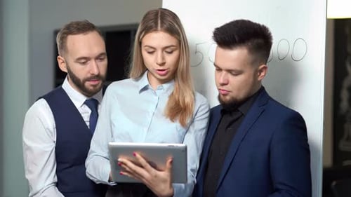 Business Colleagues Discussing Data on Tablet in Office