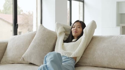 Woman Relaxing on Sofa Indoors During Daytime