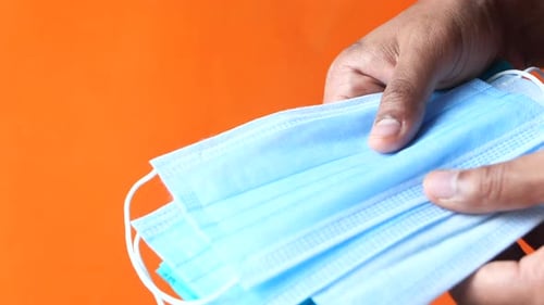 Man Hand Holding Surgical Face Mask, Close Up
