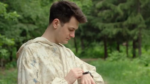 Young Adult Checking Smart Watch in Forest