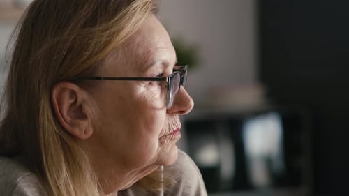 Extreme close up of thoughtful caucasian senior woman sitting in armchair