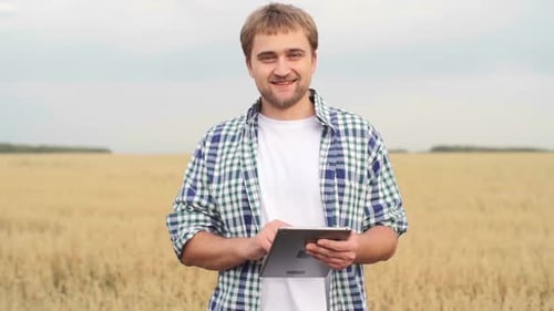Farmer Uses Tablet in Golden Wheat Field