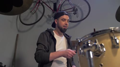 Guy Rehearsing Playing a Drum Kit