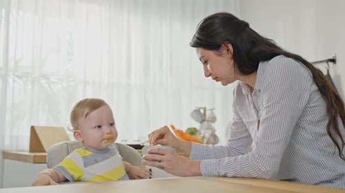 Loving Mother Feeds Baby in Bright Home