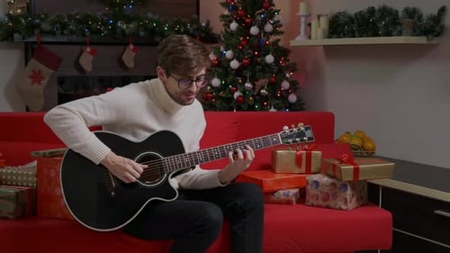 Man Plays Guitar and Sings at Christmas