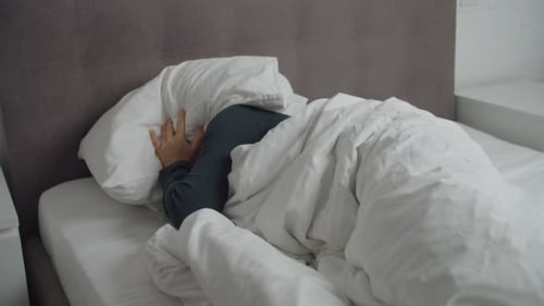 Woman Wakes Up Upset and Covers Head with Pillow
