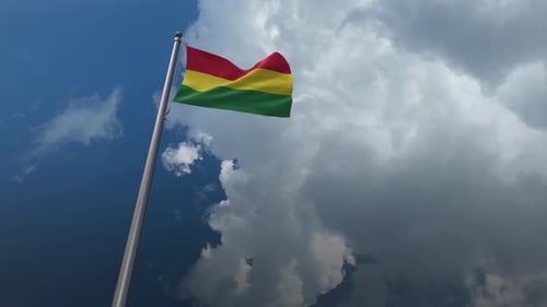 Waving National Flag on a Flagpole with Cloudy Sky