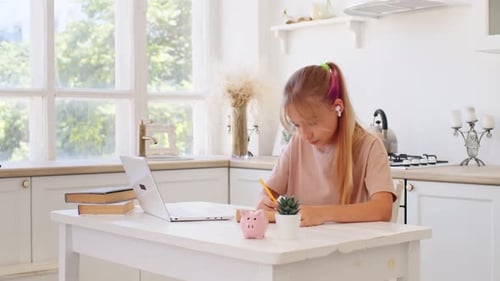 Girl Studying Online with Laptop in Bright Kitchen