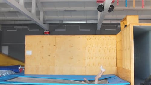 Man Practicing Acrobatic Wall Flip Dismount on Trampoline