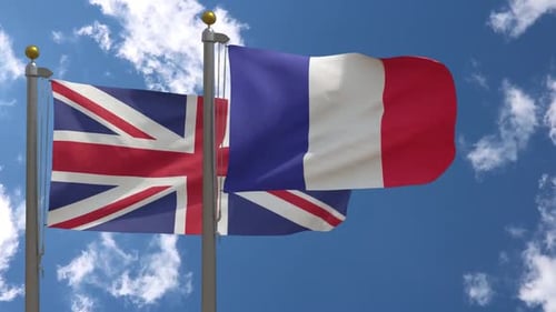 United Kingdom And France Flags Waving In Blue Sky