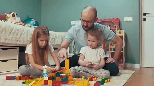 Dad and Daughters Playing With Building Blocks