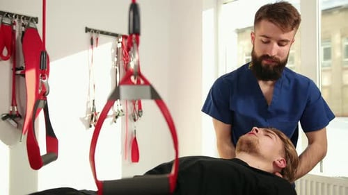 Chiropractor Adjusting Patient's Neck in Medical Office