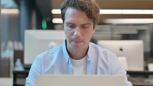 Close Up of Man Shaking Head As No Sign While Using Laptop