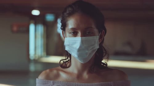 Young Woman Wearing Mask Looking at Camera