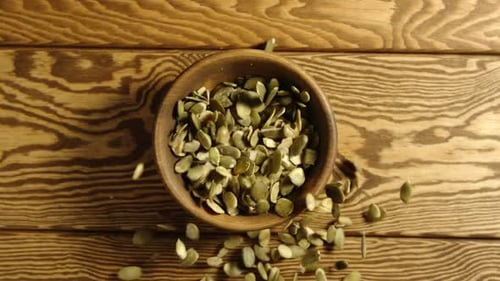 Pumpkin Seeds Filling a Wooden Bowl