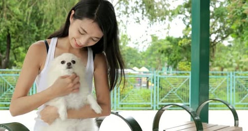 Woman Pets Dog in Urban Park Setting