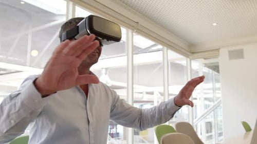 Businessman using virtual reality headset at desk in modern office 4 4k