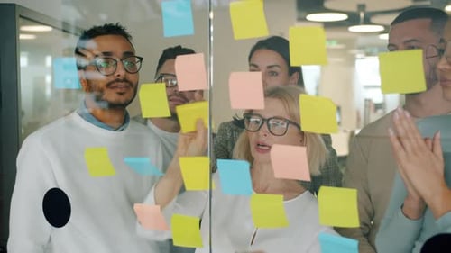 Creative Team of Coworkers Using Sticky Notes for Problem Solving Planning Work in Office