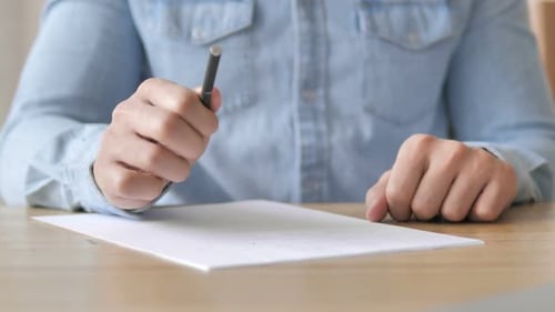 Writing on Paper With a Pen At Table