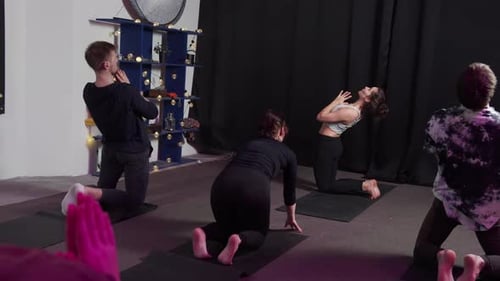 Group of Yogis Move Smoothly During Yoga Session at Sport Studio