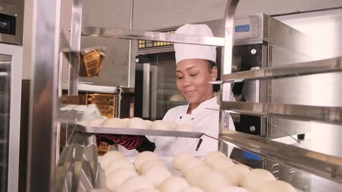 Smiling Baker Places Dough in Oven