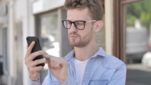 Young Adult Uses Smartphone Outside