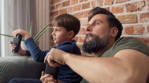 Close up video of father and son playing video game. Shot with RED helium camera in 8K.