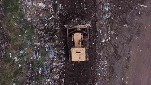 Bulldozer Works at Landfill From Above