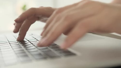Hands Typing on Silver Laptop Keyboard Close Up