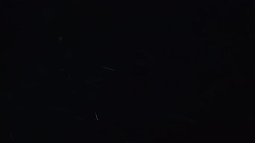 Swirling Dust Particles on Dark Background